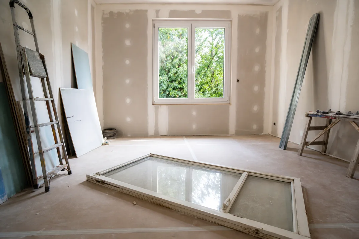 Fenêtre double vitrage fraîchement posée dans une chambre, ancien châssis simple vitrage déposé au premier plan