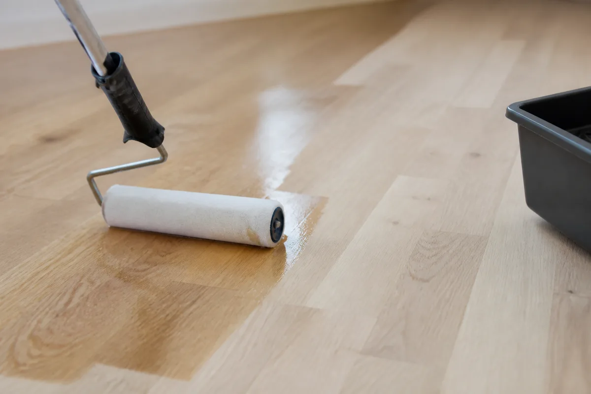Application au rouleau d&rsquo;une couche de fond dur sur des lames de parquet poncées, atelier lumineux