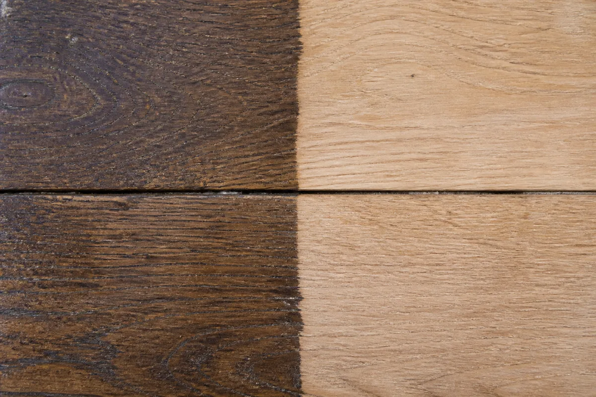 Détail d&rsquo;un parquet ancien en chêne partiellement poncé, moitié patinée et moitié bois nu clair